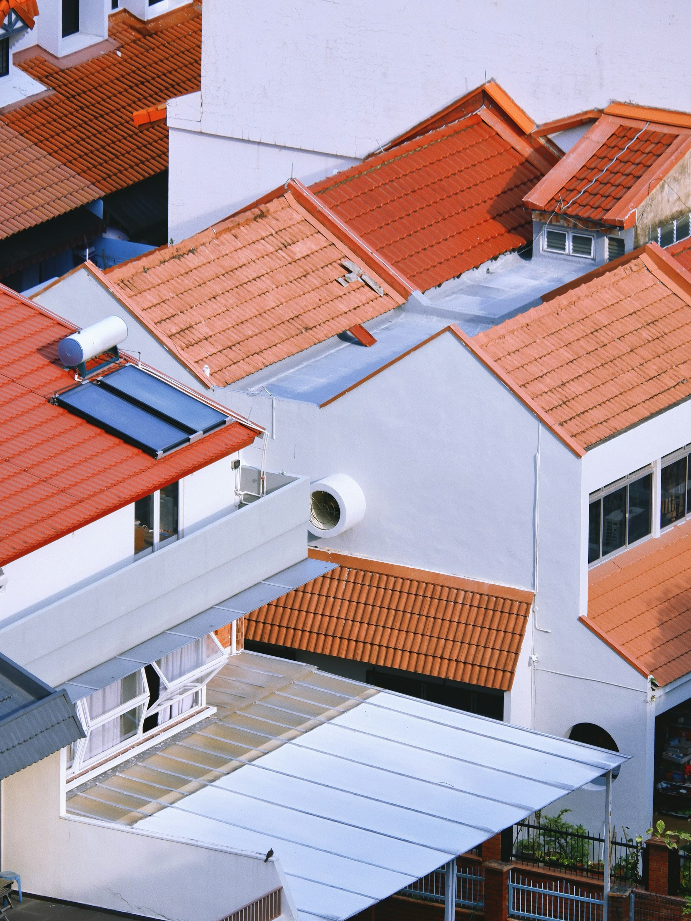 Tiled residential rooftops under warm sunlight, representing Caspian Construction's roofing focus