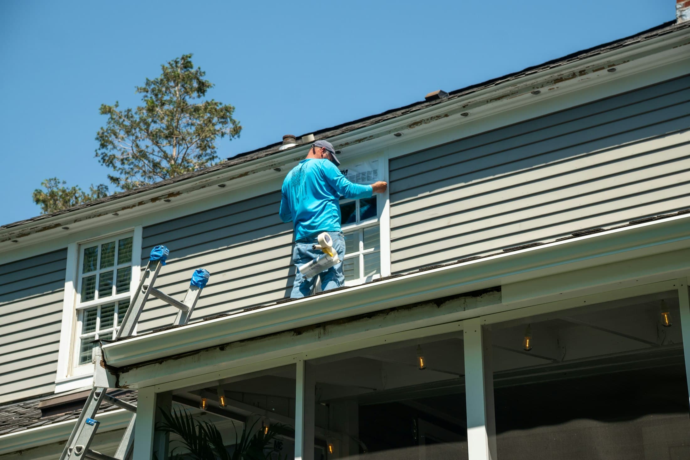 Installer placing window flashing on a roof