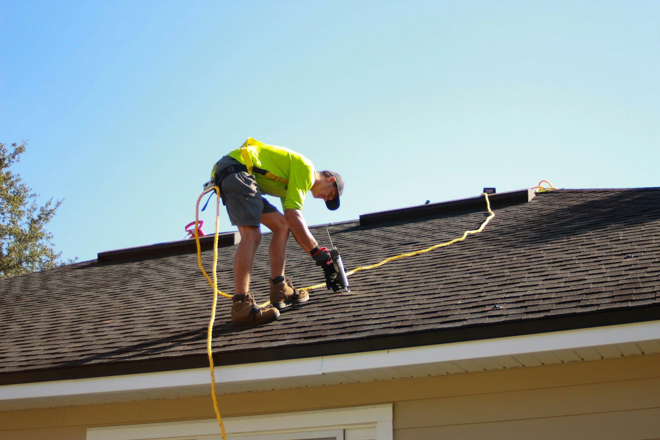 Roofing contractor using a power drill during a new roof installation
